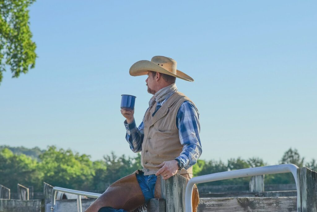 man standing while holding blue cup