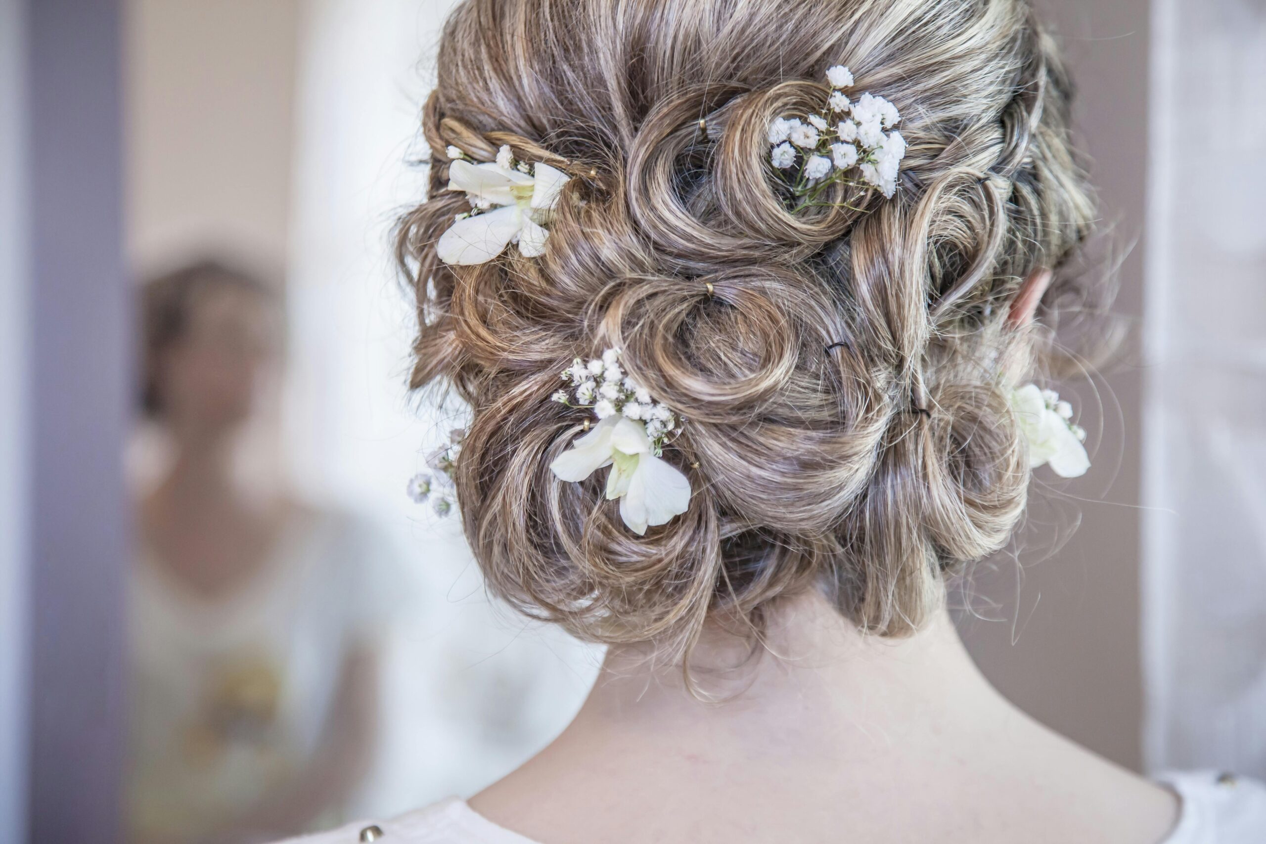 Close-up of an elegant bridal hairstyle featuring delicate white flowers, perfect for a wedding day.