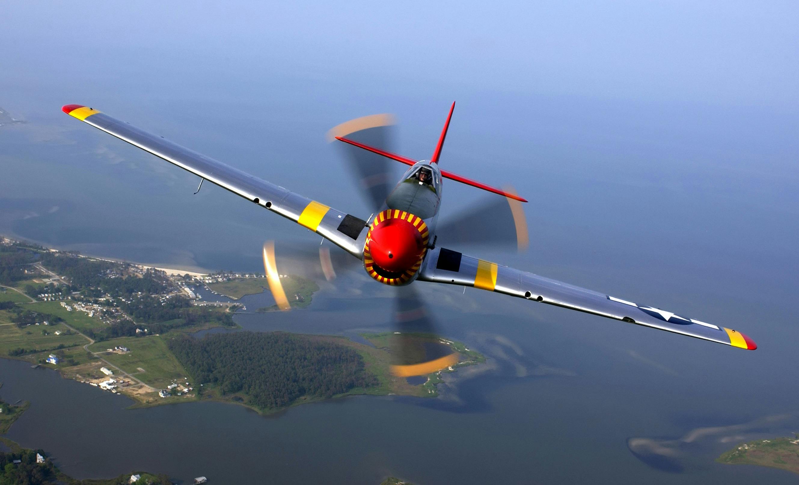 A vintage fighter aircraft, P-51 Mustang, flying over c


<div class=